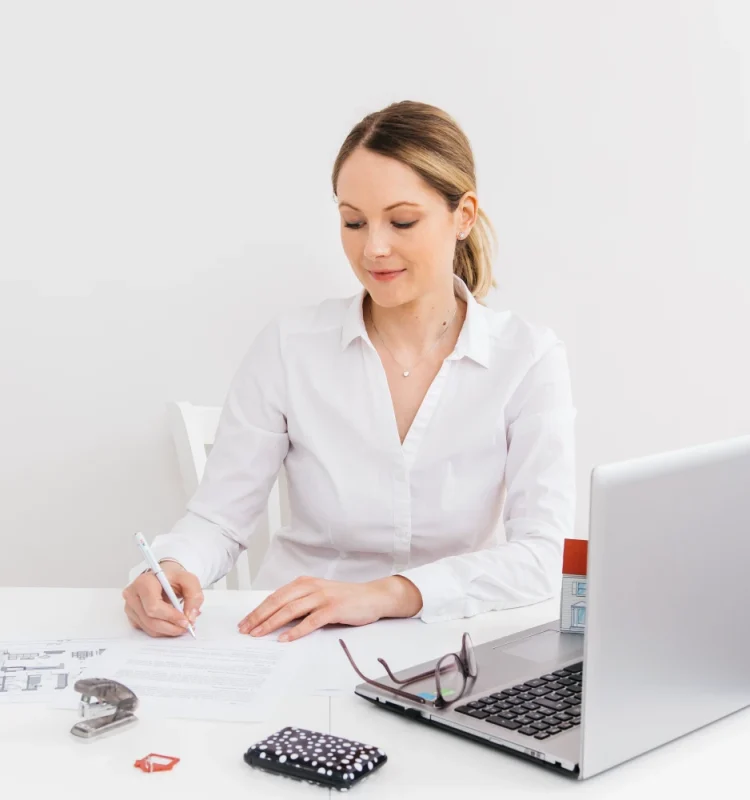 young-woman-office-doing-paperwork-front-laptop